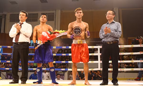 Ông Nguyễn Phan Huy Khôi trao giải thưởng Number 1 cho võ sĩ Nguyễn Quang Huy (đỏ) giành chiến thắng trong trận thách đấu.
