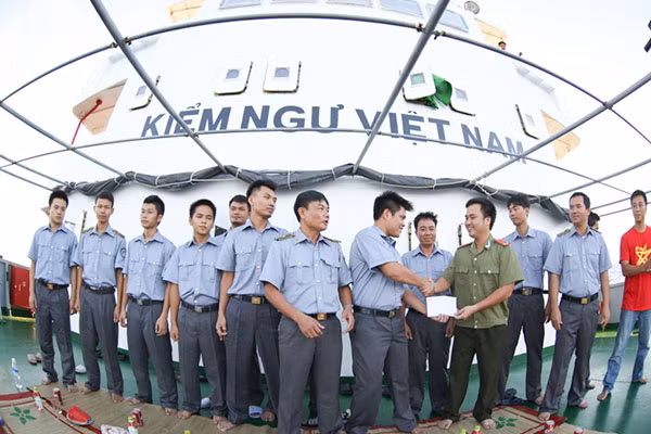 Tác giả đại diện cho Đoàn Thanh niên Báo CAND tặng quà động viên tuổi trẻ tàu KN22 đang làm nhiệm vụ tại vùng biển Hoàng Sa (ảnh chụp tháng 6-2014).