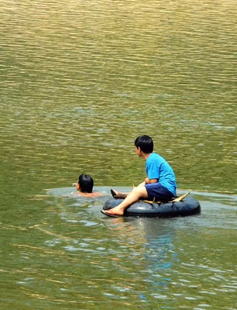 Người dân làng Tắc Rối dùng ruột xe bơm căng làm phương tiện vượt sông. Ảnh Hữu Phúc.
