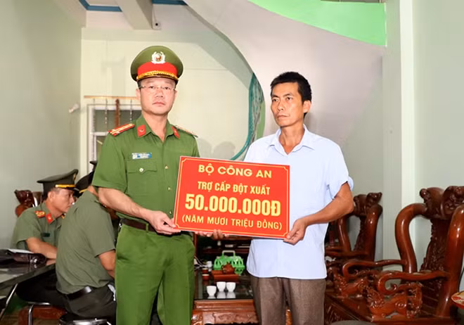 Đại tá Thân Văn Duy, Phó Giám đốc Công an tỉnh Bắc Giang thừa uỷ quyền của Bộ trưởng Bộ Công an trao tiền hỗ trợ cho gia đình Thượng sỹ Nguyễn Văn Mạnh.