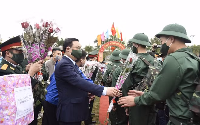 Đồng chí Vương Đình Huệ, Ủy viên Bộ Chính trị, Bí thư Thành uỷ Hà Nội tặng hoa chúc mừng các tân binh.