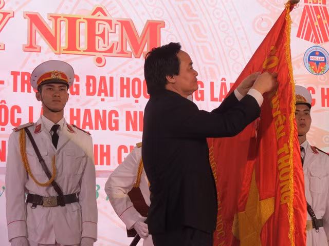 Bộ trưởng Bộ GD&ĐT Phùng Xuân Nhạ gắn Huân chương Độc lập hạng Nhất lên lá cờ truyền thống của trường.