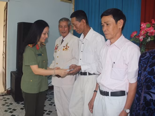 Thượng tá Nguyễn Thúy Quỳnh, Phó Tổng Biên tập Báo CAND trao quà cho các gia đình chính sách.