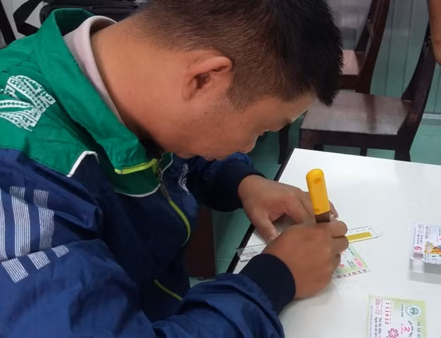 Đối tượng Đức thực hiện lại hành vi cắt gián vé số để làm giả vé số trúng thưởng giải đặc biệt.