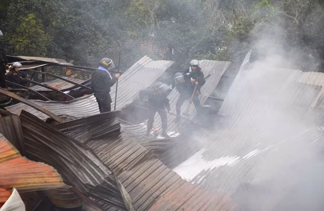 Tháo dỡ mái tôn để cứu hỏa.