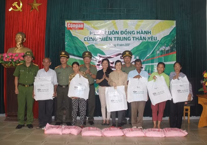 Đại diện Báo CAND, Công ty TNHH Carlsberg Việt Nam và Công an tỉnh Quảng Bình trao quà cho người dân xã biển Hải Trạch.