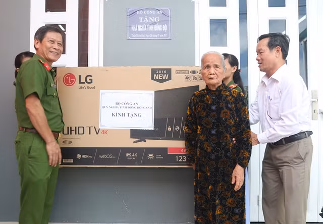 Lãnh đạo Cảnh sát PCCC tỉnh Thừa Thiên- Huế tặng quà cho gia đình bà Hoàng Thị Hà tại lễ bàn giao nhà.