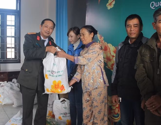 Trung tá Nguyễn Văn Long, Phó Ban Thư ký Tòa soạn, Trưởng VPTT Báo CAND tại miền Trung trao quà Tết cho các CCB ở huyện Triệu Phong, tỉnh Quảng Trị.