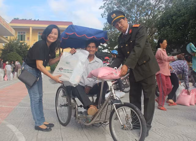 Đại diện Báo CAND và Công ty TNHH Carlsberg Việt Nam trao quà cho một hộ dân ở xã Phong Bình.