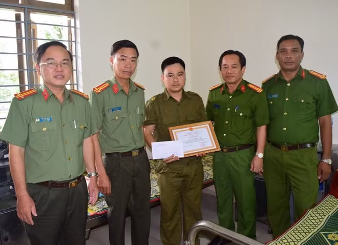 Đại tá Đặng Ngọc Sơn, Phó Giám đốc Công an tỉnh Thừa Thiên- Huế (đứng thứ 2 bên phải) tặng giấy khen và trao thưởng cho đồng chí Cương.