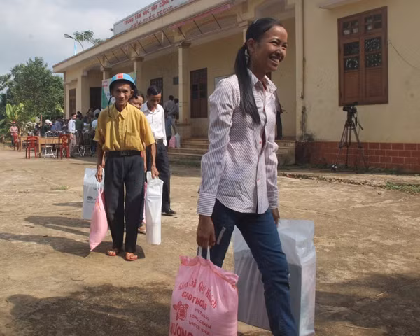 Người dân xã ven biển Vĩnh Trung vui mừng khi được Báo CAND và Công ty TNHH Carlsberg Việt Nam trao quà hỗ trợ sau bão.