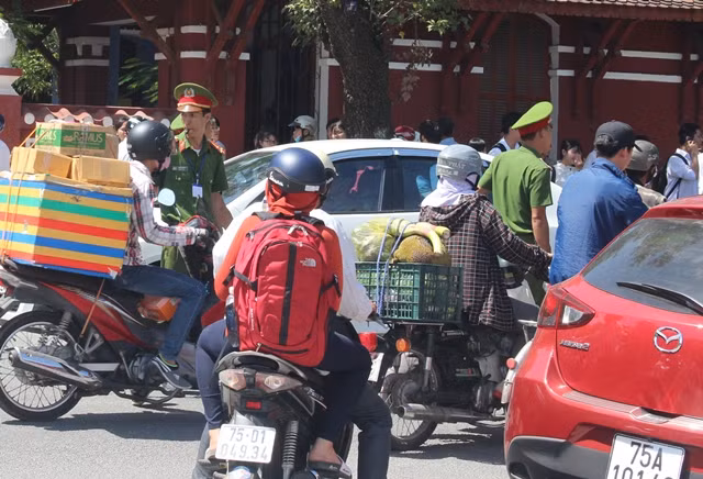 Một chiến sĩ công an phân luồng điều tiết giao thông trên đường Lê Lợi, TP Huế khi có rất đông phụ huynh đến đón sĩ tử sau buổi thi môn Ngữ Văn.