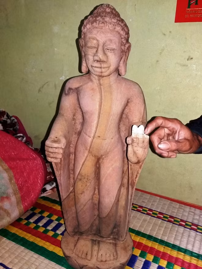 Bức tượng Phật bằng đá nặng khoảng 50kg được ông Tứ phát hiện lúc đào vườn. Ảnh: Tiến Vinh.