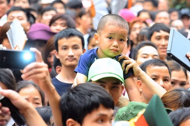 Biển người cùng chờ đợi dưới chân núi khiến cho không khí trở nên ngột ngạt, nhiều em nhỏ cũng phải chen chân theo cha mẹ.