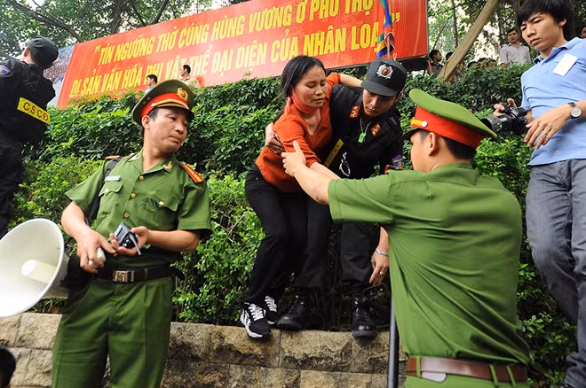 Các chiến sĩ Công an dìu, bế người bị ngất xỉu và các cháu nhỏ ra khỏi đám đông chen lấn.