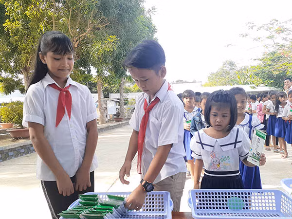 Các em học sinh thực hành gấp vỏ hộp sữa sau khi uống để dễ thu gom và tái chế. Các em học sinh thực hành gấp vỏ hộp sữa sau khi uống để dễ thu gom và tái chế.