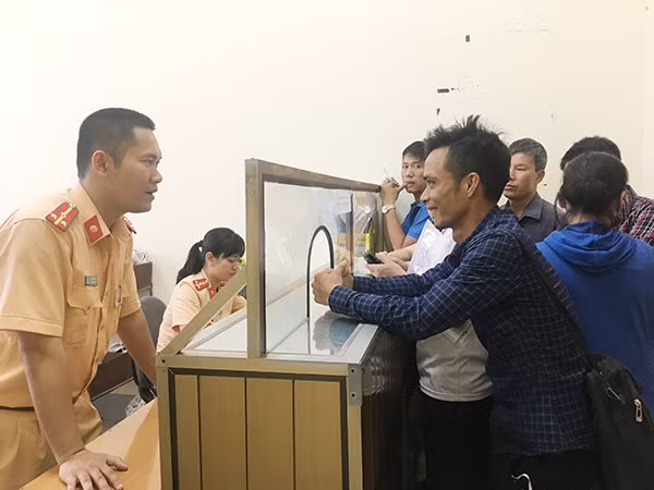 Cán bộ CSGT hướng dẫn thủ tục cấp đăng ký phương tiện cho người dân. Cán bộ CSGT hướng dẫn thủ tục cấp đăng ký phương tiện cho người dân.