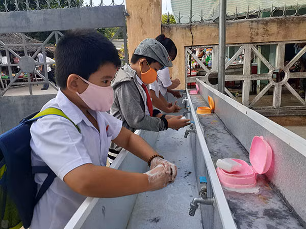 Học sinh được hướng dẫn đeo khẩu trang ở nơi đông người và rửa tay trước khi vào lớp học. Học sinh được hướng dẫn đeo khẩu trang ở nơi đông người và rửa tay trước khi vào lớp học.