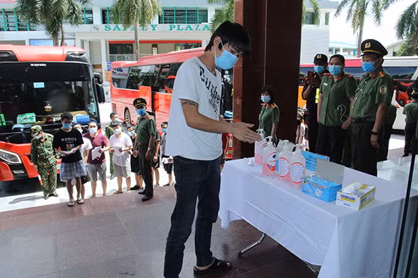 Những người được trao trả đeo khẩu trang và khử khuẩn trước khi vào làm thủ tục.