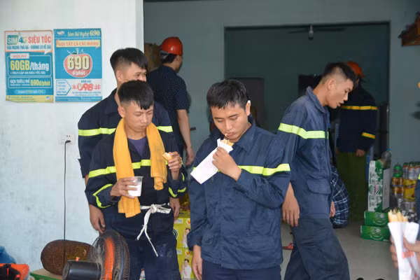 Các CBCS tham gia chữa cháy tranh thủ dùng bữa trưa để túc trực đề phòng đám cháy bùng phát trở lại giữa thời tiết nắng nóng khắc nghiệt.