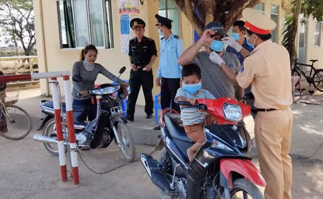 Cán bộ, chiến sĩ Công an Đồng Tháp tuyên truyền phòng, chống dịch COVID-19 và phát khẩu trang cho người dân tại Cửa khẩu Quốc tế Dinh Bà.
