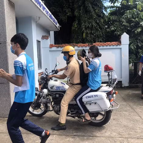 Một trường hợp thí sinh quên giấy dự thi được chiến sĩ CSGT hỗ trợ. Ảnh: Bùi Hào.