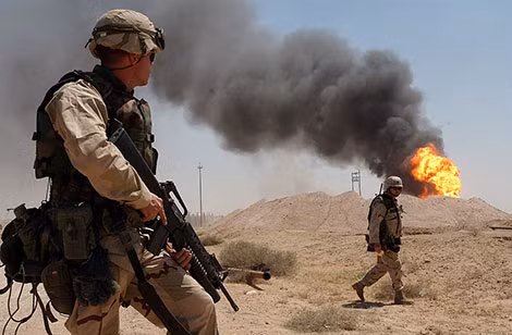 Lính Mỹ bên ngọn lửa từ một giếng dầu ở Iraq.
