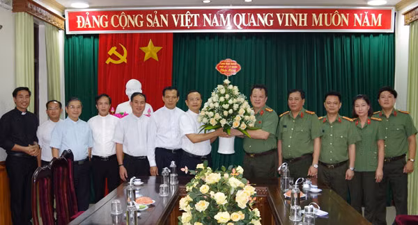 Linh mục Bùi Quang Tào - Chính xứ An Phú (xã Thanh Hương, huyện Thanh Liêm) - Quản hạt Phủ Lý; đại diện các linh mục và bà con giáo dân trên địa bàn tỉnh tặng hoa chúc mừng Công an Hà Nam.