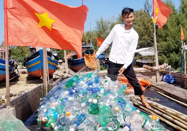 Ngư dân trẻ Trần Văn Cường với công việc vớt rác thải trên biển.