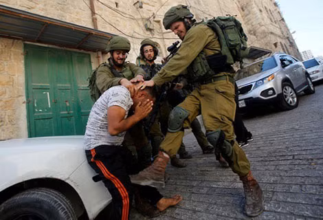 Lính Israel hành hạ một thanh niên Palestine.