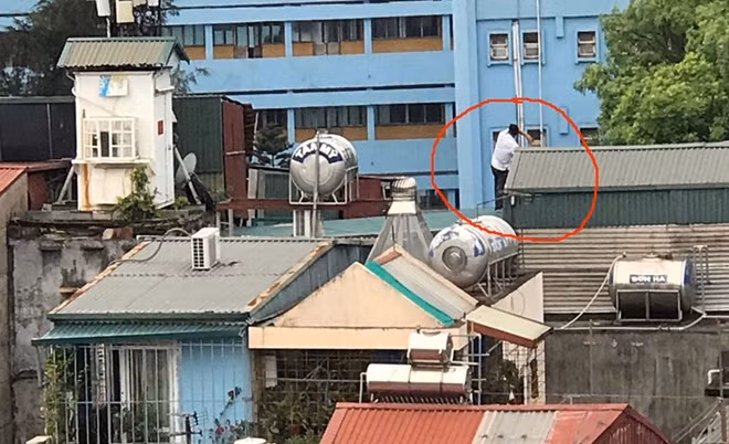 Đối tượng Mai Quốc Nam trên nóc nhà ở phường Kim Mã, Hà Nội.