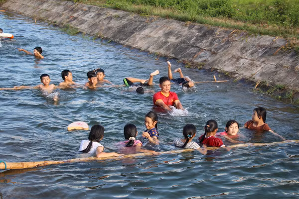 Thầy Tước dạy bơi cho trẻ em ở đoạn kênh thủy lợi thôn Lam Thủy. Thầy Tước dạy bơi cho trẻ em ở đoạn kênh thủy lợi thôn Lam Thủy.