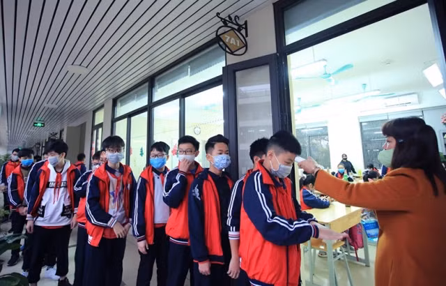 Học sinh được đo thân nhiệt trước khi vào lớp.
