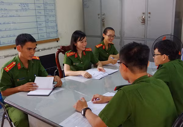 Đại úy Đinh Cẩm Nhung (thứ 2, từ trái qua) trao đổi nghiệp vụ với các đồng nghiệp.