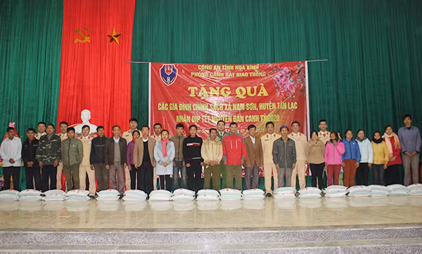 Đại tá Trịnh Văn Cường, Phó Giám đốc Công an tỉnh cùng CBCS phòng CSGT trao tặng quà cho đồng bào nghèo xã Nam Sơn.