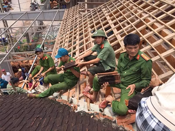 Cán bộ, chiến sỹ Công an huyện Kỳ Sơn, Nghệ An giúp dân sửa chữa nhà cửa sau lũ.