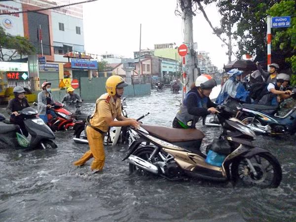 Cảnh sát giao thông TP Hồ Chí Minh giúp người dân vượt qua đoạn đường bị ngập sau cơn mưa lớn.