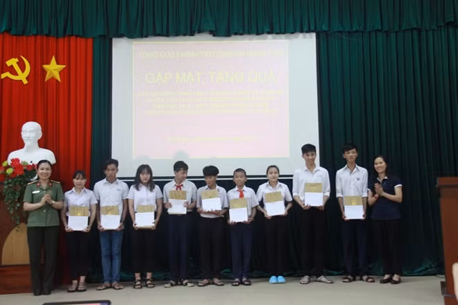Thượng tá Phạm Thị Nhàn và đại diện Công ty cổ phần tập đoàn Xây dựng Hòa Bình tặng quà các cháu học sinh.