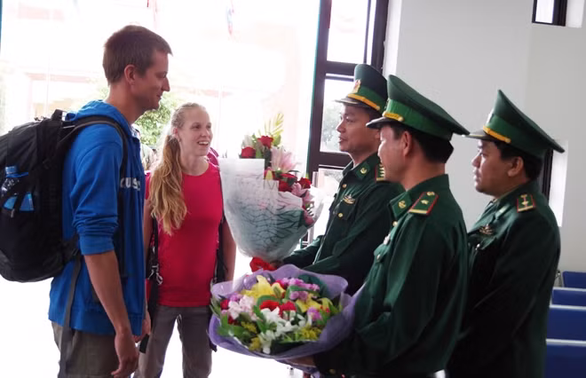 Đại diện Đồn BPCKQT Lao Bảo tặng hoa cho hai vị khách quốc tế đầu tiên nhập cảnh bằng thị thực điện tử qua đường bộ.