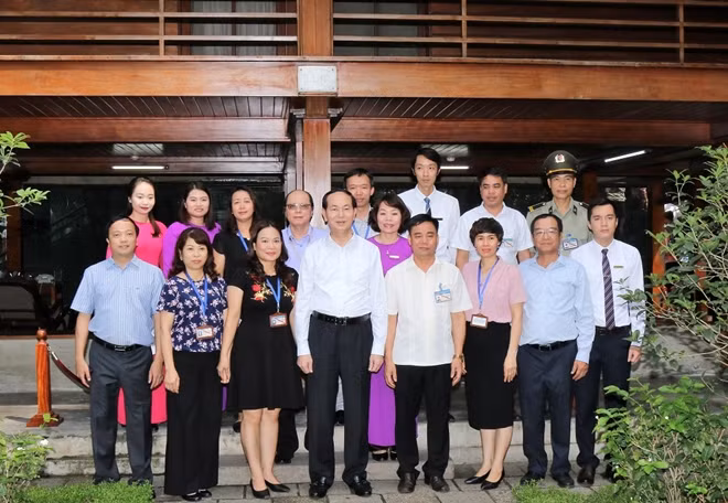 Chủ tịch nước Trần Đại Quang, Chủ nhiệm Văn phòng Chủ tịch nước Đào Việt Trung và cán bộ, nhân viên Khu di tích Chủ tịch Hồ Chí Minh bên nhà sàn Bác Hồ.