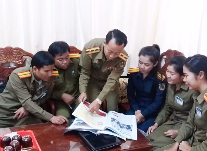 Trung tá Khăm Xỷ hướng dẫn học viên học tiếng Việt qua Báo CAND