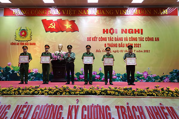 Giám đốc Công an tỉnh Bắc Giang trao tặng bằng khen cho các tập thể.