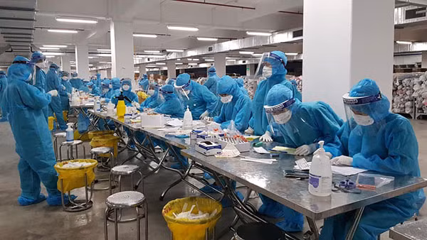Các nhân viên y tế của BV Việt Nam - Thụy Điển Uông Bí lấy mẫu xét nghiệm cho công nhân ở Bắc Giang liên tục trong nhiều giờ để kịp tiến độ.