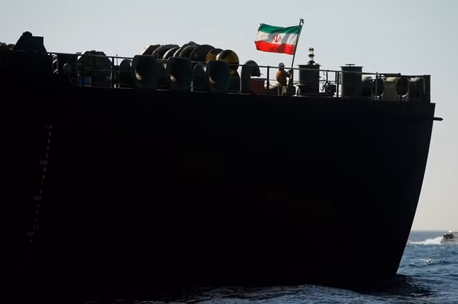 Một thành viên thủy thủ đoàn dương cờ Iran trên tàu Adrian Darya 1. Ảnh Reuters.