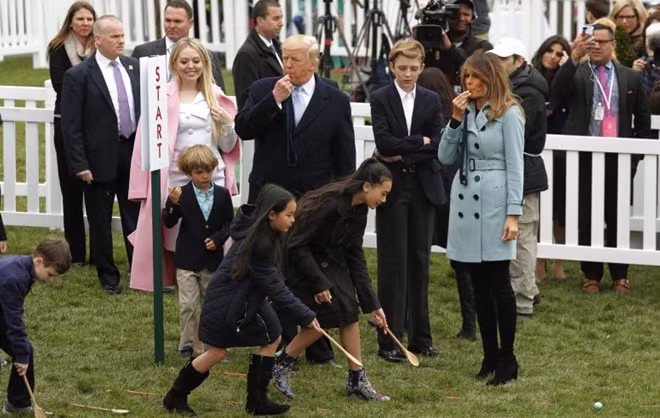 Tổng thống Mỹ Donald Trump và Phu nhân Melania, bên cạnh là con trai Baron, thổi còi để bắt đầu cuộc đua lăn trứng dành cho trẻ em.