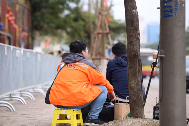 Đến giữa trưa, dù số lượng phóng viên có thưa thớt đi chút nhưng vẫn còn một số người quyết bám trụ lại. Trong ảnh là hai phóng viên của đài SBS, Hàn Quốc. Một phóng viên thuộc đài SBS chia sẻ chân tình khi đang ăn vội một ổ bánh mì: "Ai cũng muốn chụp lại những khoảnh khắc quan trọng trước hội nghị. Dù đó là hành động gì chăng nữa, chúng tôi không thể bỏ qua".