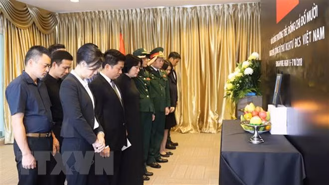 Cán bộ, nhân viên Đại sứ quán Việt Nam tại Singapore mặc niệm tưởng nhớ nguyên Tổng Bí thư Đỗ Mười. (Ảnh: Xuân Vịnh/TTXVN)