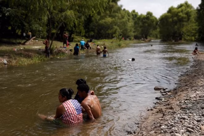 Những người di cư nán lại bên một con suối ở Tapanatepec, Mexico.
