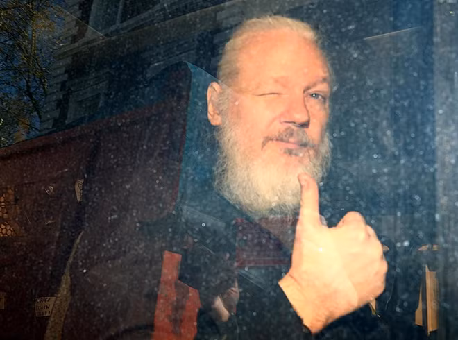 Assange sau khi bị tống lên xe cảnh sát. Ảnh Reuters.