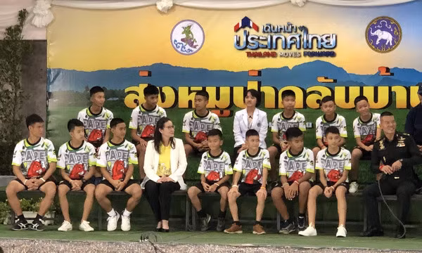 12 thành viên đội bóng Lợn Hoang và huấn luyện viên 25 tuổi hôm nay lần đầu xuất hiện trước truyền thông trong chương trình "Thái Lan tiến lên", được phát trực tiếp trên nhiều kênh truyền hình của Thái Lan. Ảnh: The Guardian